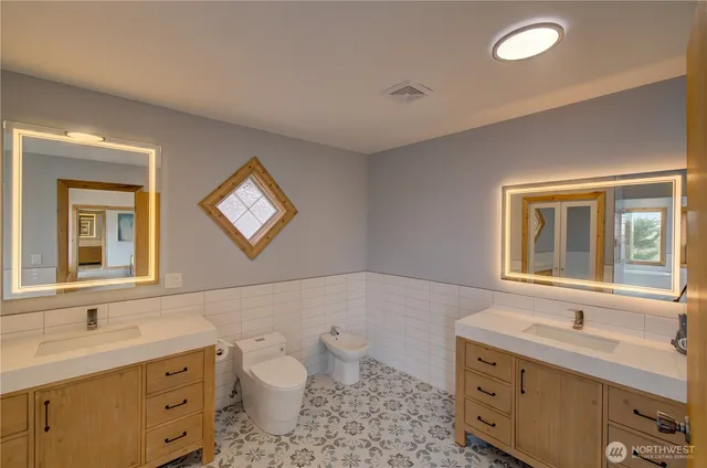 a bathroom with a toilet sink and mirror