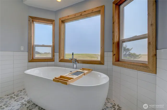 a bath tub sitting in a bathroom next to a window