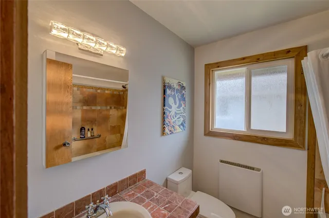 a bathroom with a toilet a sink and a large mirror