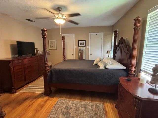 a bedroom with a bed and a flat tv screen on dresser