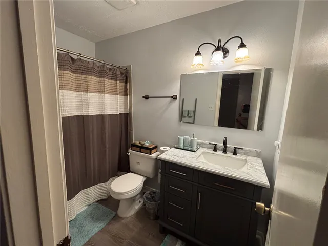 a bathroom with a toilet sink double vanity and mirror