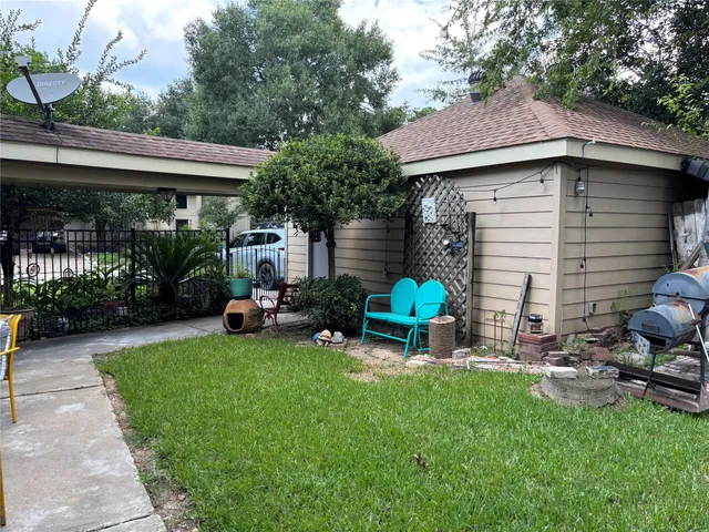 a view of a chair and table in backyard of the house