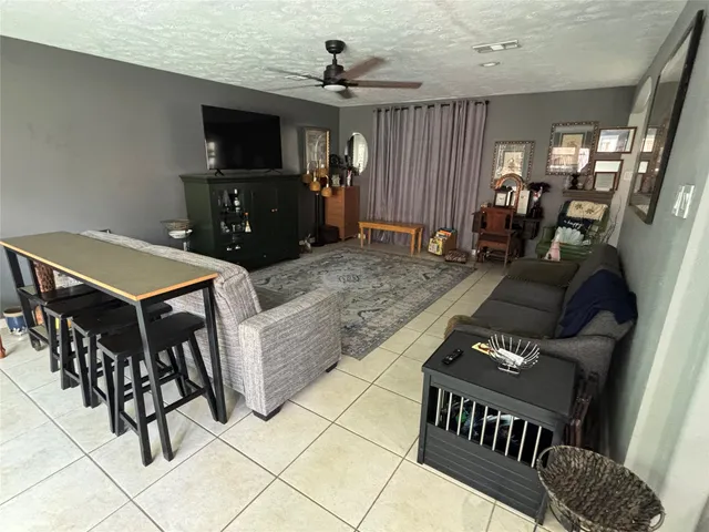 a living room with furniture a flat screen tv and kitchen view