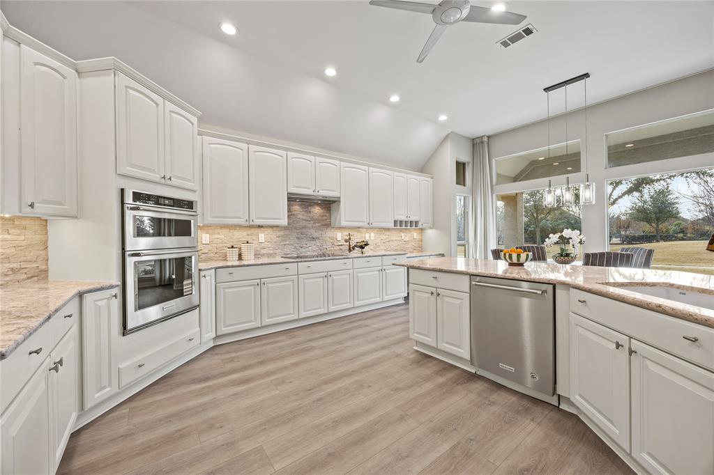 10409 Countryside Drive Denton, TX 76207 - Photo 17 of 38 Kitchen featuring lofted ceiling, pendant lighting, white cabinetry, light granite counters, and stainless steel appliances