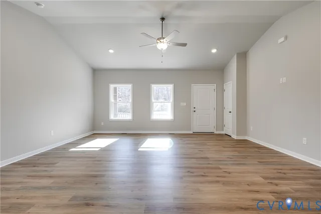 an empty room with wooden floor and window