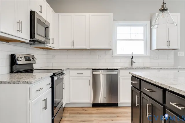 a kitchen with stainless steel appliances granite countertop a stove a sink and a refrigerator