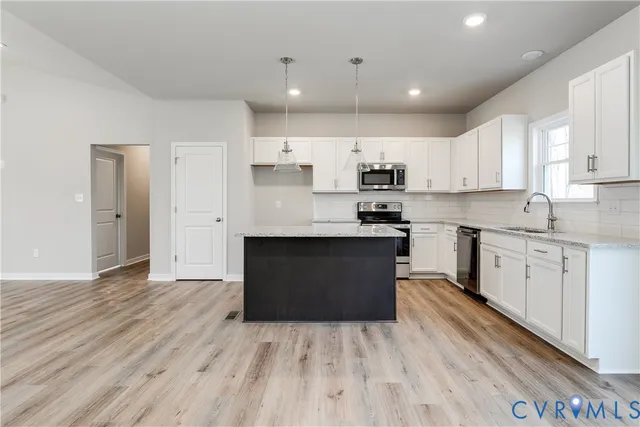 a kitchen with stainless steel appliances granite countertop a stove a sink and a refrigerator