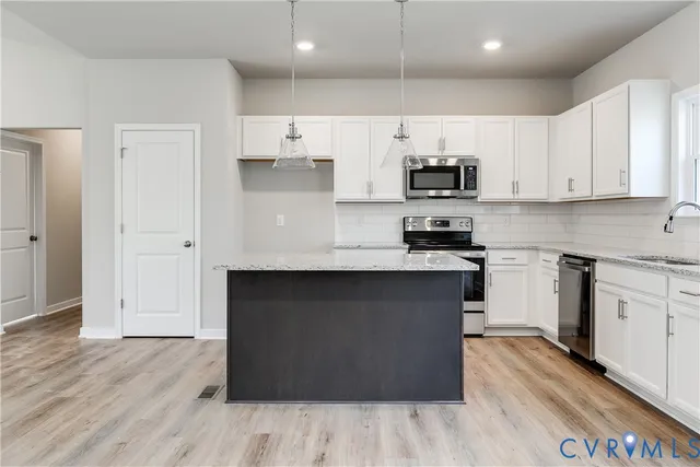 a kitchen with stainless steel appliances granite countertop a sink stove and microwave