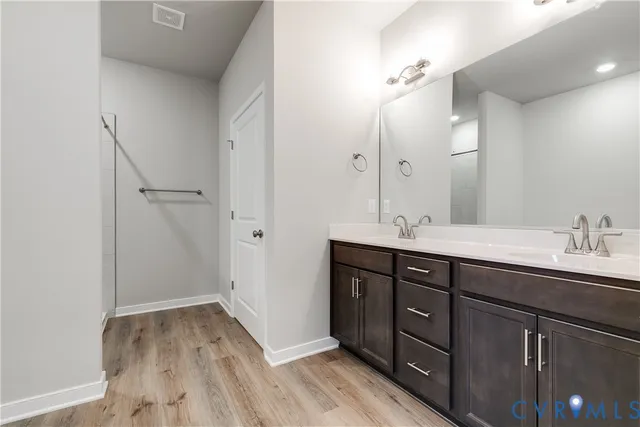 a bathroom with a granite countertop sink a large mirror and shower