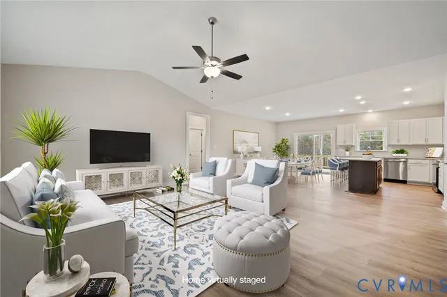an empty room with wooden floor kitchen view and a window