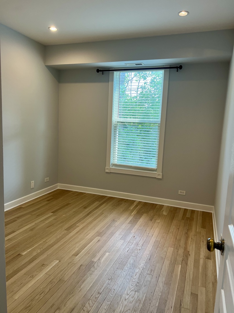 473 Metropolitan Street, Unit 473 Aurora, IL 60502 - Photo 5 of 8 a view of an empty room with wooden floor and a window
