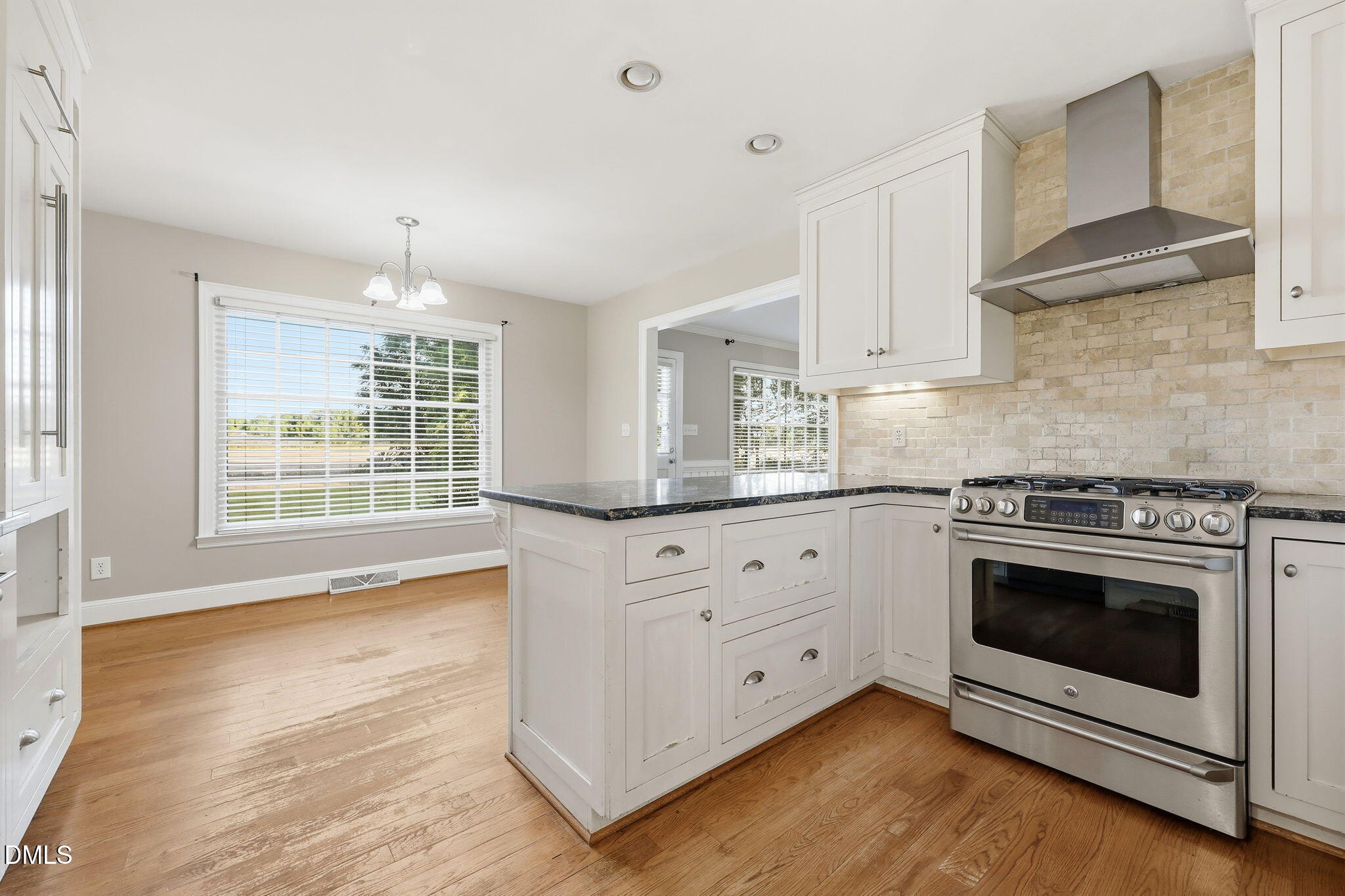1130 Prospect Church Road Dunn, NC 28334 - Photo 10 of 47 a kitchen with stainless steel appliances white cabinets and wooden floors