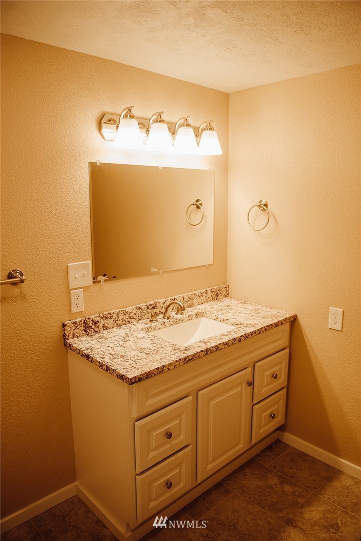 116 Eadon Road Toledo, WA 98591 - Photo 15 of 34 a bathroom with a granite countertop sink and a mirror