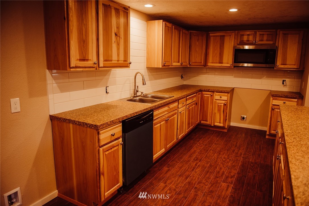116 Eadon Road Toledo, WA 98591 - Photo 7 of 34 a kitchen with stainless steel appliances granite countertop wooden cabinets a sink and dishwasher with wooden floor