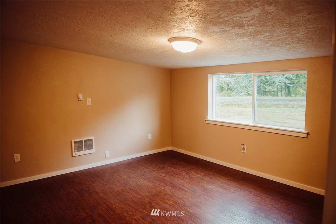 116 Eadon Road Toledo, WA 98591 - Photo 10 of 34 an empty room with wooden floor and windows