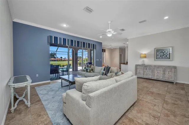 a living room with furniture and a ceiling fan