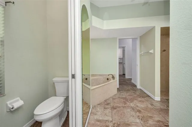 a bedroom with a bed lamp and a large window