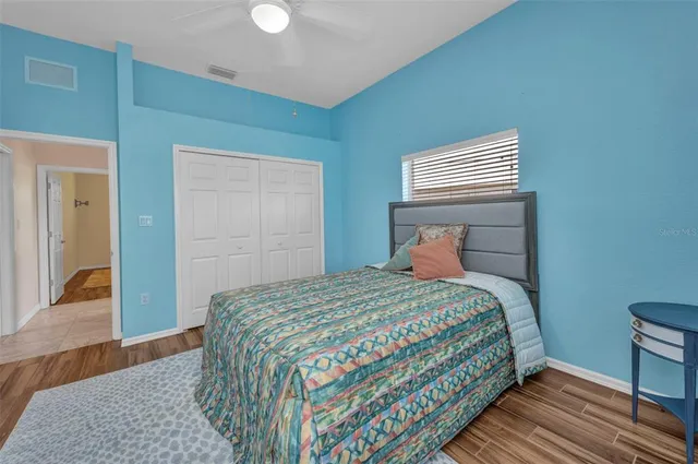 a bedroom with a bed and wooden floor