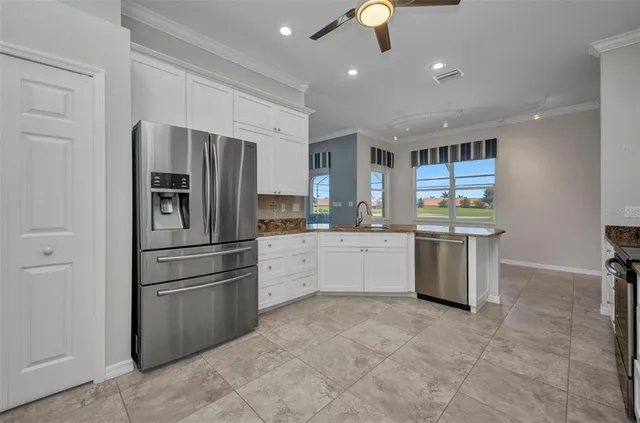 a kitchen with granite countertop white cabinets and stainless steel appliances