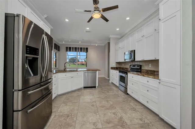 a large kitchen with stainless steel appliances granite countertop a stove and a sink