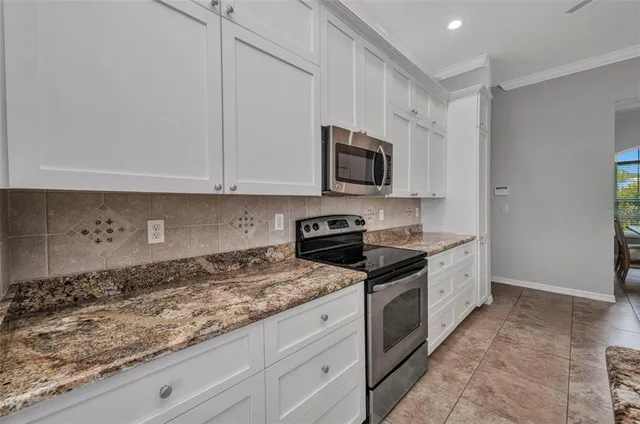 a large kitchen with stainless steel appliances granite countertop a stove and a sink