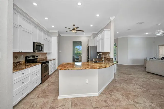 a living room with stainless steel appliances kitchen island granite countertop furniture and a kitchen view