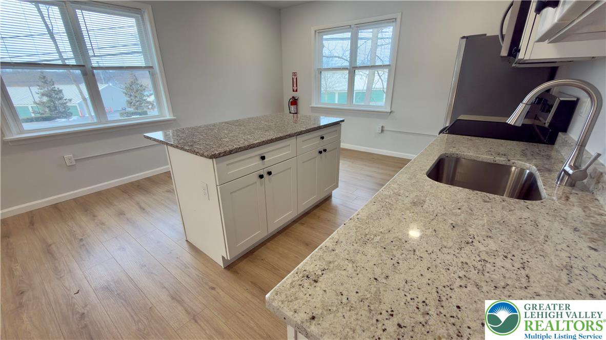 403 North Walnut Street, Unit B Bath, PA 18014 - Photo 10 of 31 a kitchen with granite countertop a sink and a wooden floor