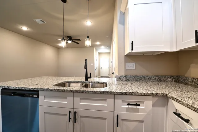 a kitchen with granite countertop cabinets a sink and dishwasher
