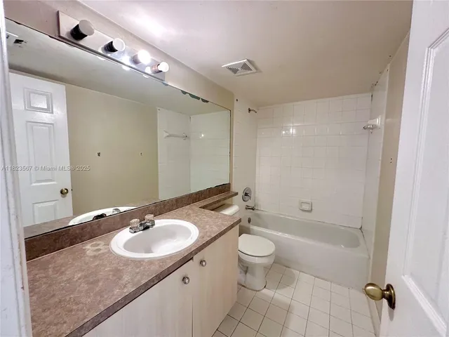 a bathroom with a granite countertop sink a toilet a mirror and shower
