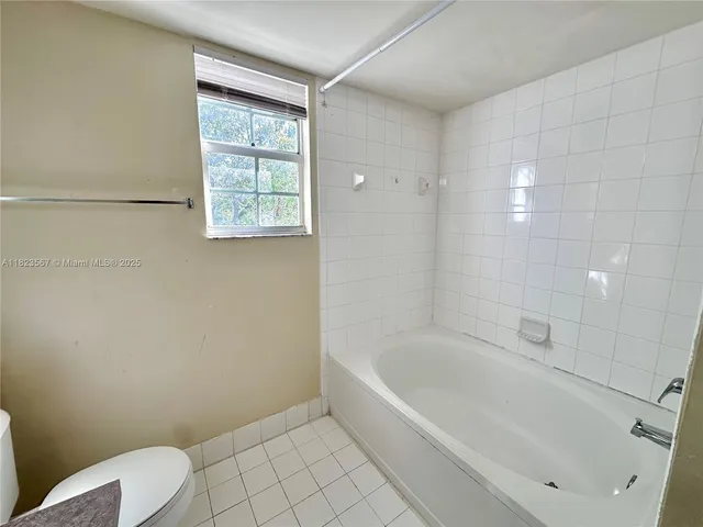 a white bath tub sitting next to a toilet