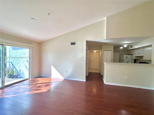 a view of empty room with wooden floor and window