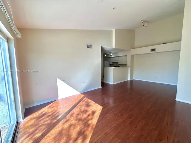 a view of empty room with wooden floor