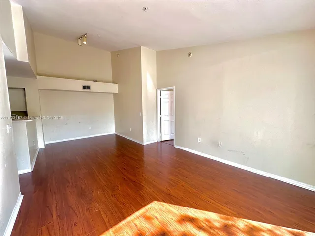 a view of empty room with wooden floor