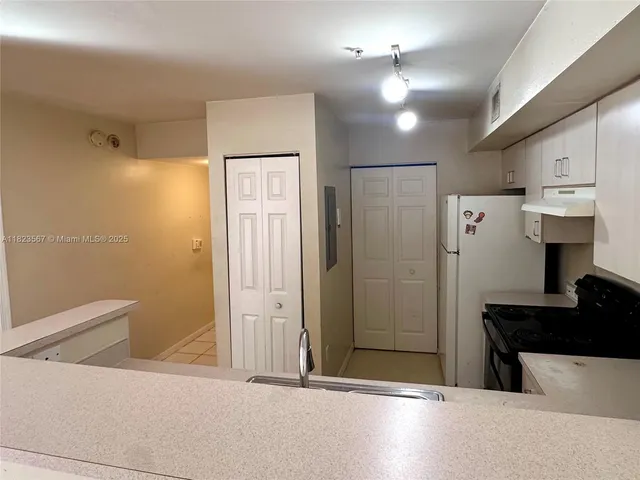 a view of a hallway with a refrigerator
