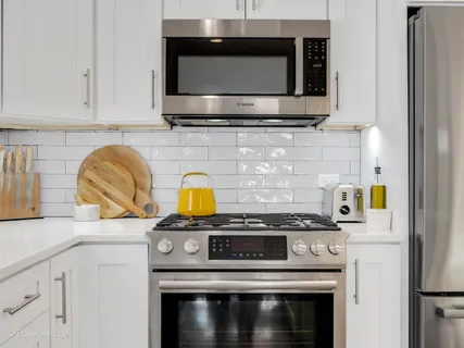 a kitchen with stainless steel appliances granite countertop a stove and a microwave