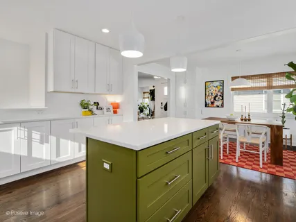 a kitchen with kitchen island granite countertop a sink cabinets and wooden floor