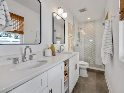 a bathroom with a double vanity sink toilet and shower