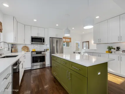 a kitchen with kitchen island granite countertop a sink a counter space stainless steel appliances and cabinets