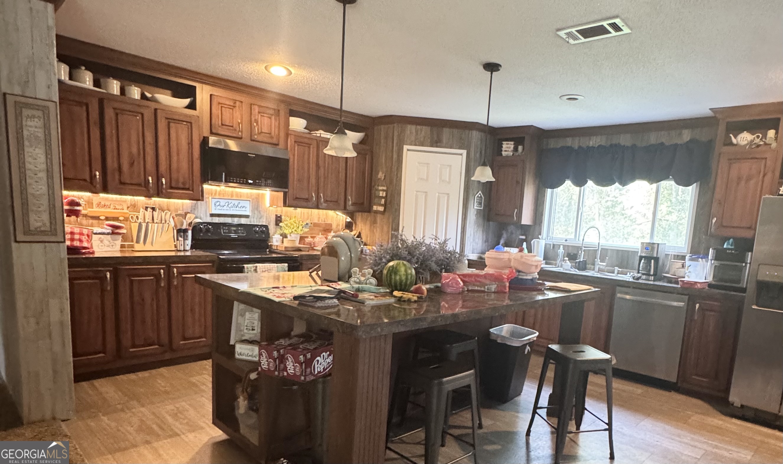 92 Graham Lane Claxton, GA 30417 - Photo 4 of 18 a kitchen with kitchen island granite countertop a sink appliances and cabinets