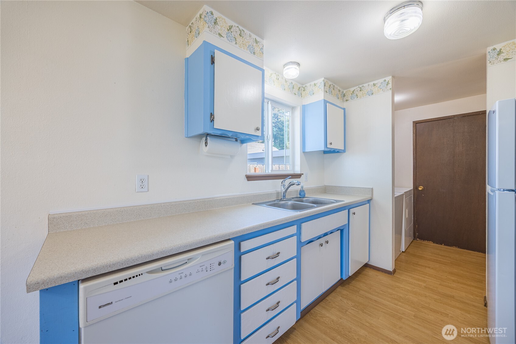 323 West Fir Street Sequim, WA 98382 - Photo 11 of 40 a kitchen with a sink cabinets and a wooden floor