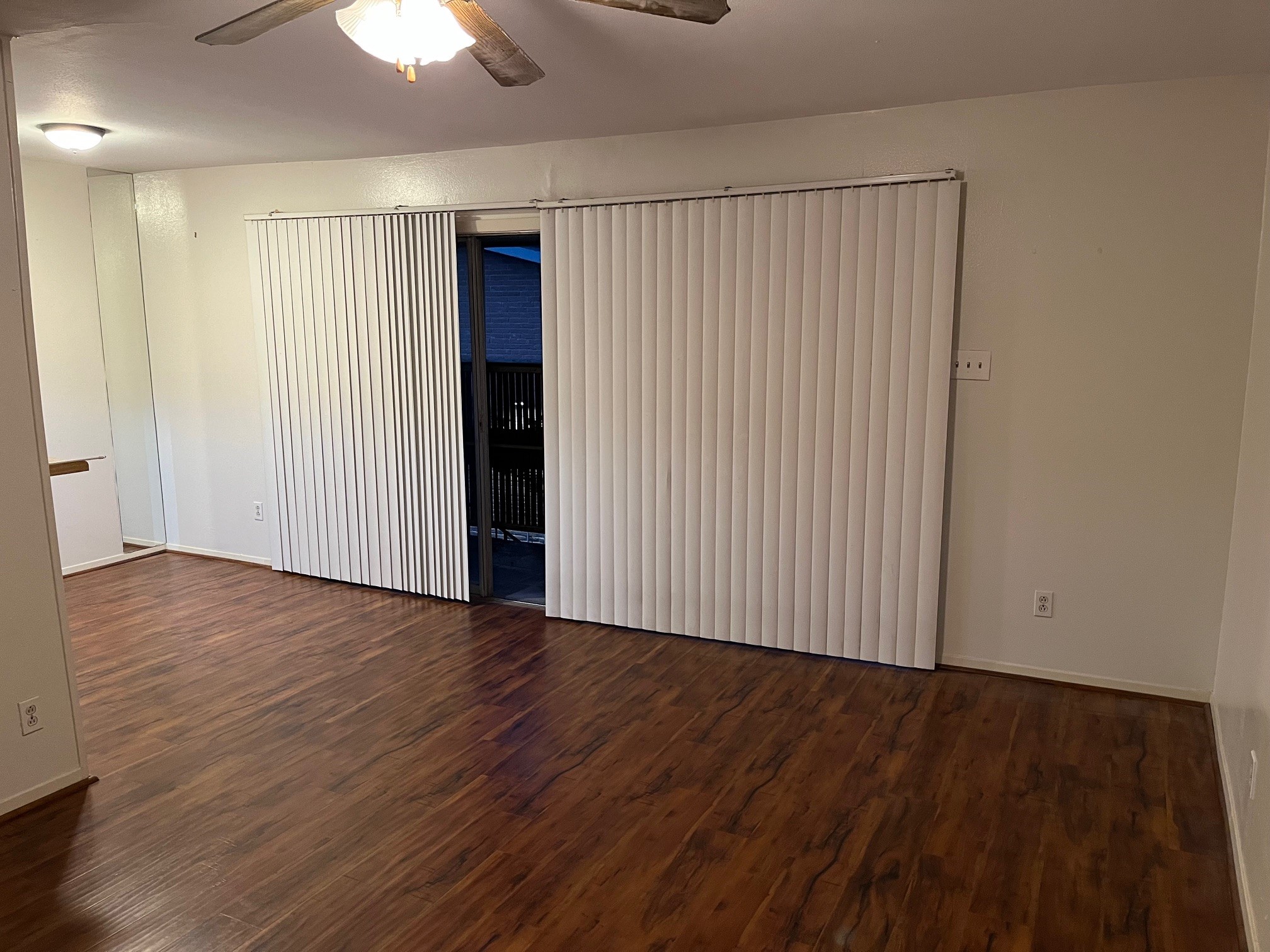 3938 West Alabama Street, Unit 12 Houston, TX 77027 - Photo 5 of 25 Spacious living area with wood-look flooring, ceiling fan & access to private balcony.