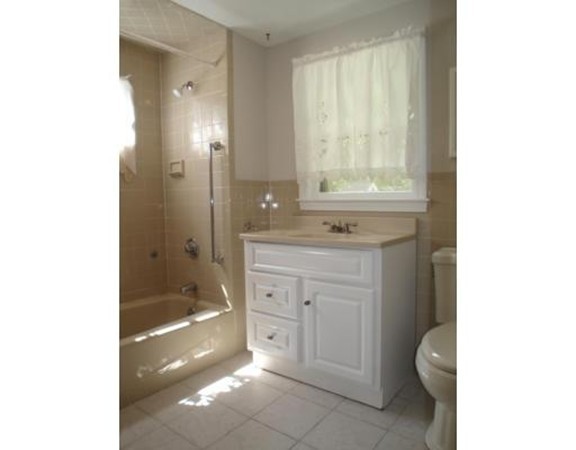 383 Marrett Road Lexington, MA 02421 - Photo 14 of 18 a bathroom with a granite countertop sink a toilet and shower