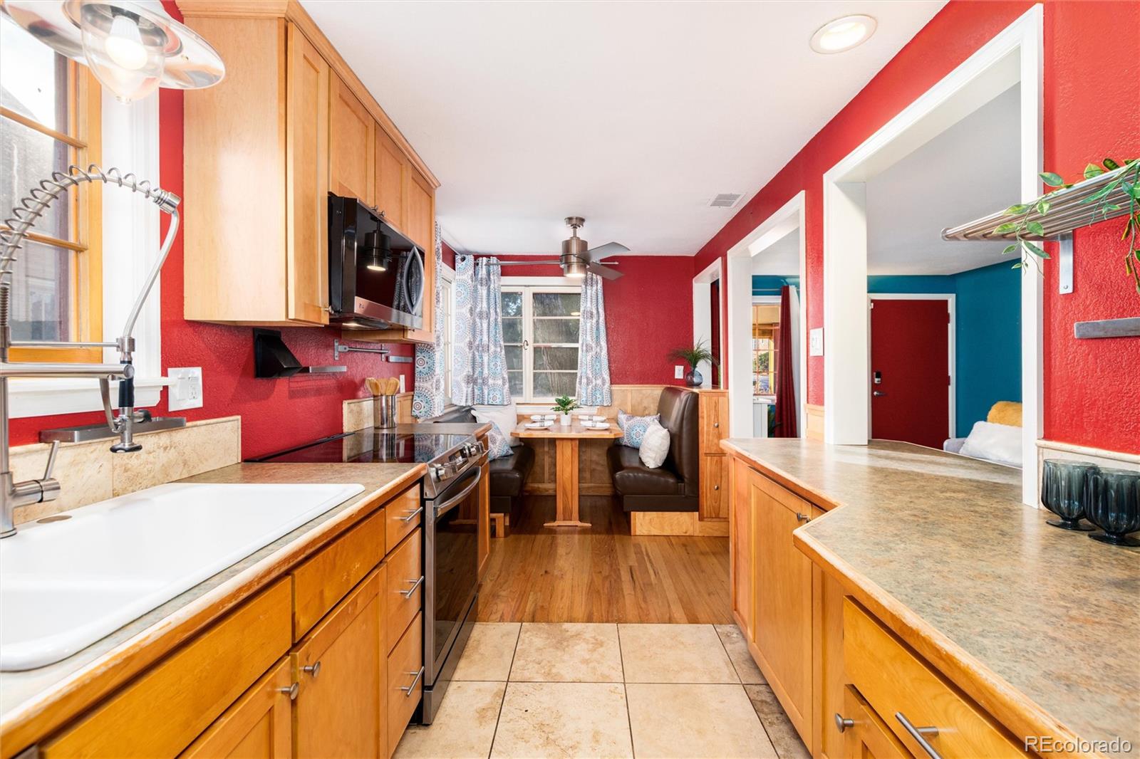 3100 Ames Street Wheat Ridge, CO 80214 - Photo 17 of 39 a large kitchen with stainless steel appliances kitchen island granite countertop a large kitchen island a stove a sink and a refrigerator