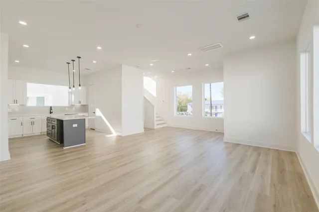 a view of kitchen with kitchen island stainless steel appliances wooden floor and window