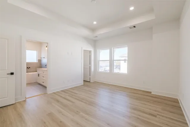 a view of a room with wooden floor and bathroom view