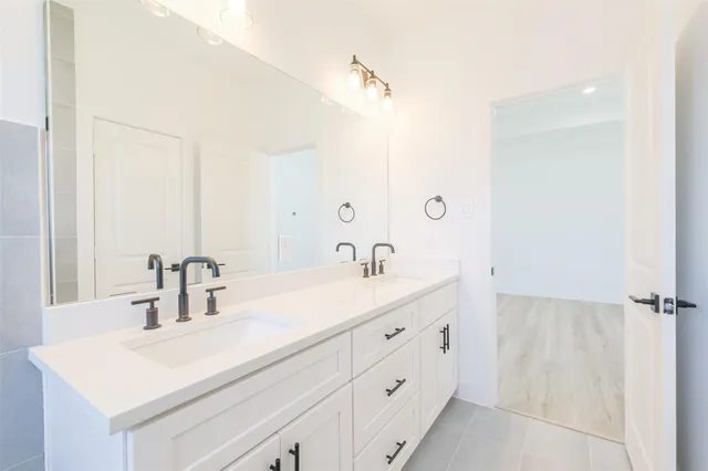 a bathroom with a double vanity sink and mirror