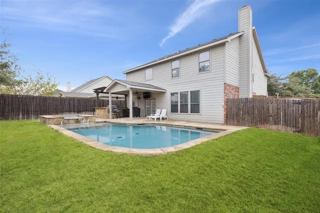 a view of a house with pool and a yard