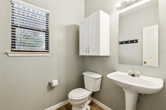 a bathroom with a sink a toilet and mirror