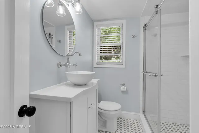 a bathroom with a sink a toilet and a mirror