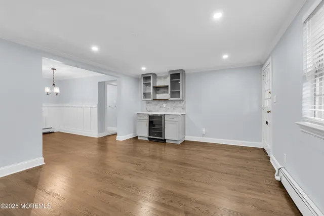 an empty room with wooden floor fireplace and windows